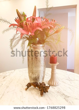 Summer flowers, Lilies in a vase on a round marble table. Interior of a dining room with flowers.