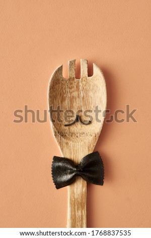 Cartoon man with a mustache from farfalle pasta and wooden spoon, conceptual cozy photography for food blog or ad