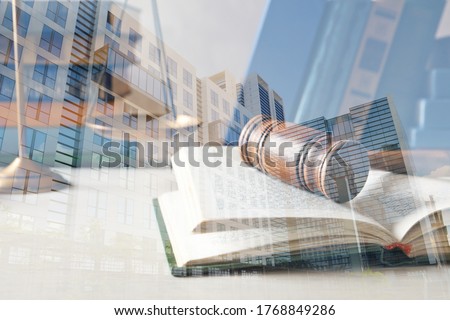 Law protection. Double exposure of book with wooden gavel and buildings