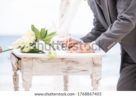 Caribbean beach white wedding ceremony in Curaçao. Signing the wedding certificate