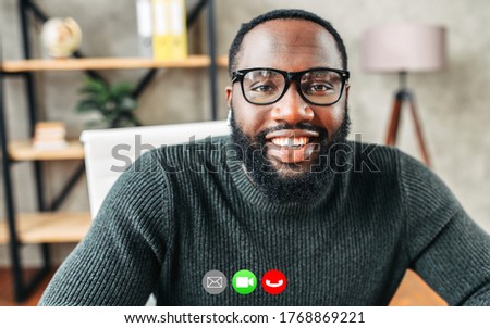 An African-American guy looks at camera while talking via video call