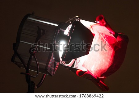 Powerful artificial light with metal shutters for work in a film studio or professional photo studio with a fixed red filter