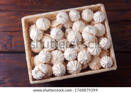 sigh or homemade meringue is a sweet made from egg whites, sugar and lemon in the basket on wooden table