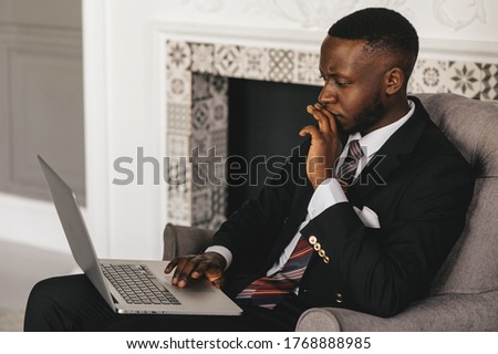 Always make a total effort, even when the odds are against you. African american businessman is working, using his laptop while resting in the cafe