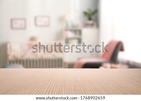 Empty wooden table in baby room interior Royalty-Free Stock Photo #1768902659