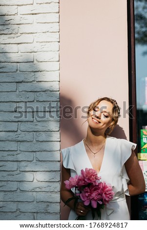 Beautiful young bride with a bouquet of peonies.