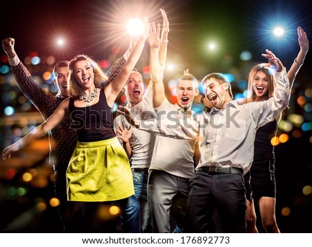Cheerful group of young people dancing at party 