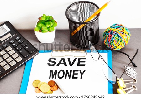 SAVE MONEY written on paper with office tools
