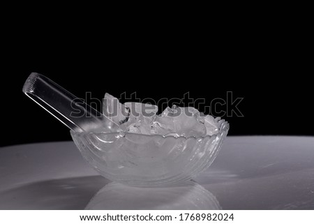 Ice bucket and plate along with ice holder isolated against black background and photographed with beautiful bokeh