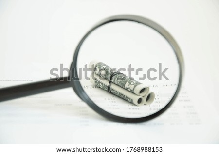  twisted dolars are visible through a magnifier. assessment of earnings. small business. High quality photo