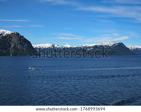 Deep blue waters of whittier, Alaska and view of a small fishing boat on the ocean.