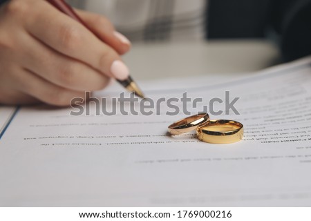 Woman signing marriage contract, closeup Royalty-Free Stock Photo #1769000216