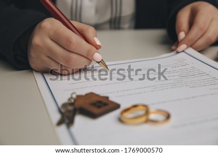 Hands of wife, husband signing decree of divorce, dissolution, canceling marriage, legal separation documents, filing divorce papers or premarital agreement prepared by lawyer. Wedding ring Royalty-Free Stock Photo #1769000570