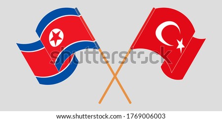 Crossed and waving flags of North Korea and Turkey