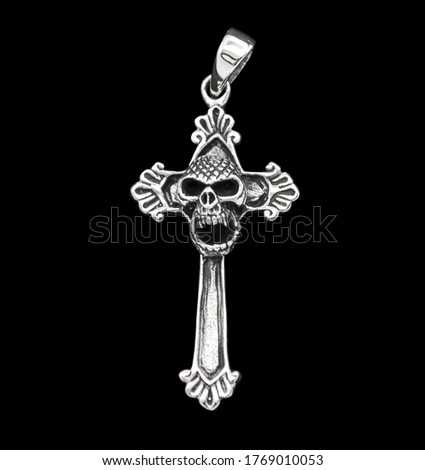 Silver jewelry. Pendant on the neck. Amulet. Occult symbolism. 
Gothic cross with a skull.