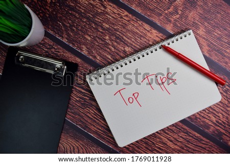 Top Tips write on a book isolated wooden table.
