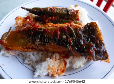 Whiptail stingrays fish spicy sour with rice on a white plate. Famous Malaysia food.