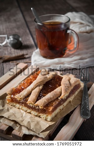 Close-up of a delicious quince tart accompanied by a delicious cinnamon tea, ideal for the cool autumn evenings, where the reddish tones predominate