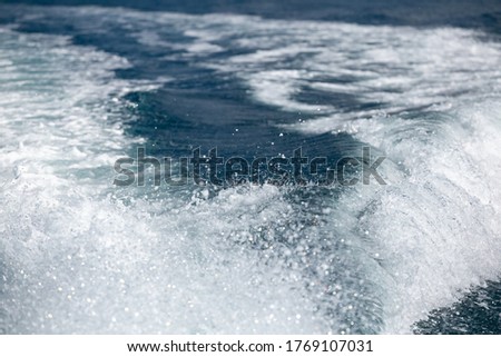 A beautiful scenery of the water trail foaming behind a boat in the ocean