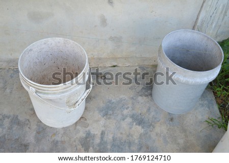 photo of two large buckets on cement