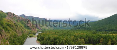 Panoramic view of the mountain landscape of Khakassia, Russia. White Iyus River. Thick fog and low cloudiness over the mountains and summer taiga. Summer tourism in Khakassia, Siberia