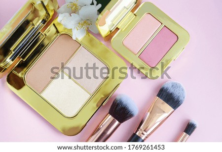 premium makeup brushes, eyeshadow palette and blush on a colored pink background, creative cosmetics flat lay
