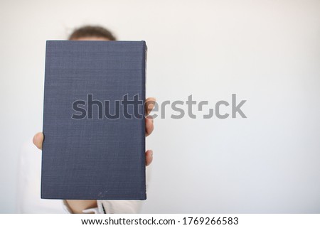 A young girl holds a book in her hand