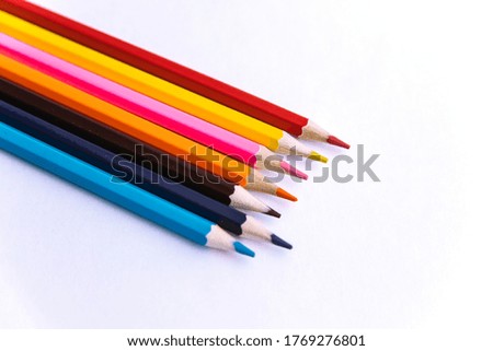 Colored pencils on a white background. Variety of colors. School supplies. Stationery.