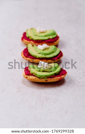 stock photo pink toast bread with avocado and vegan vegan and vegetarian hummus with feta cheese and gray background