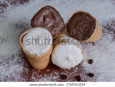 Chocolate and vanilla ice cream in a glass. Cold dessert. Brown and white ice cream. Ice cream sprinkled with powdered sugar.
