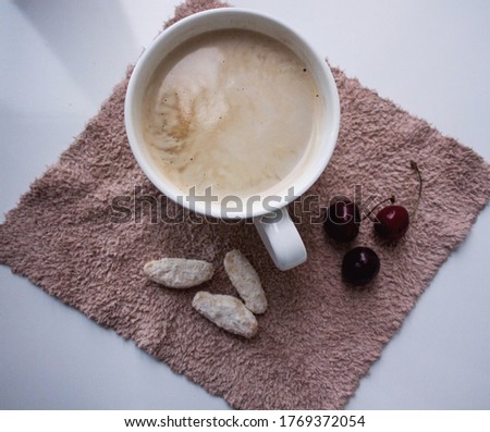 Coffee with cookies and cherries on a napkin. Morning still life