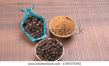 Indian spices - black pepper powder, Black peppercorns scattered on wooden background and Black pepper Powder.