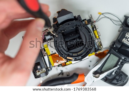 Taking apart and repairing digital camera. Close up image of camera parts. Royalty-Free Stock Photo #1769383568