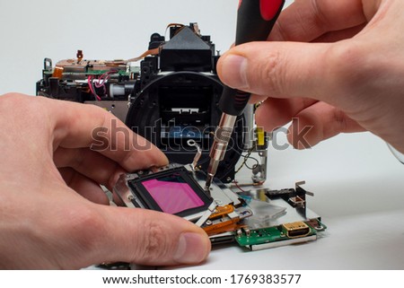 Taking apart and repairing digital camera. Close up image of camera parts. Royalty-Free Stock Photo #1769383577