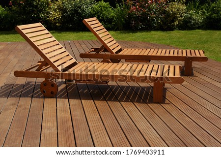 two lounge chair on an exotic wood terrace Royalty-Free Stock Photo #1769403911