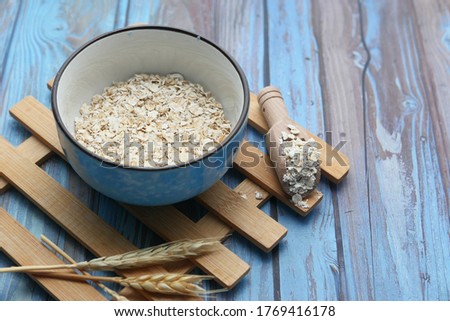 uncooked oats flakes wooden background, close up