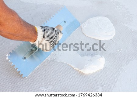 Builder using plastering tool for finishing wall and floor