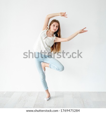 young girl dancing contemp on white wall background