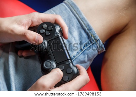 Game joystick in the hands of a teenager close-up. Teenage boy sits with a joystick at home, top view. Computer games. Play online.
