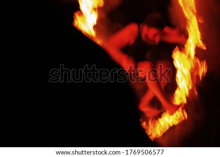 Against background of human silhouette another blurry person falls out of firestorm. Unrecognizable blurred anonymous silhouette in night