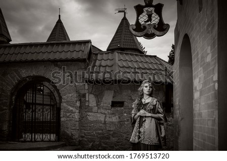 Beautiful young blonde girl in the medieval clothes in the fortress. The princess is looking for. Black and wight picture. The Lady the Heart. 