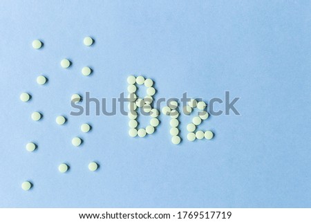 Yellow pills forming shape to B12 alphabet on blue background. Vitamin complex. Concept, health care, healthy nutrition. Healthy lifestyle. Food additive. copy space. Soft focus. blurry background.