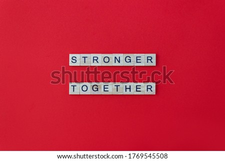 Words Stronger Together. Wooden blocks with lettering on red background. Minimal concept. Top view, layout