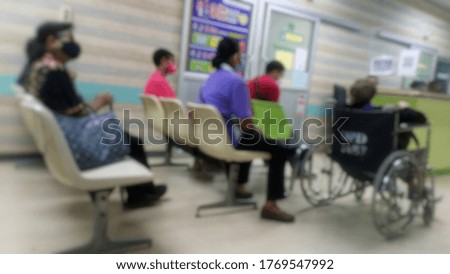 The blurred abstract background of the patients sitting on a chair,wheelchair waiting to see a doctor in the hospital... sitting spaced social to prevent the spread of the Covid 19 virus .