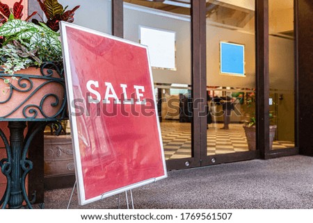 Large red sale sign placed in front of the store at the mall