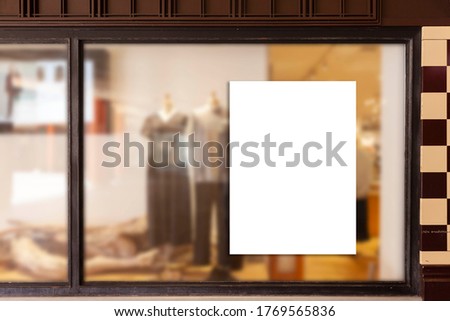 Blank promotion poster on glass window at storefront