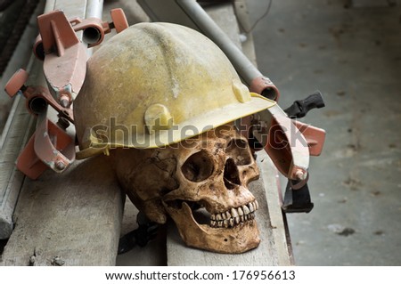still life photography, Human skull wearing safety helmet with tripod on wood plank in surveyor concept