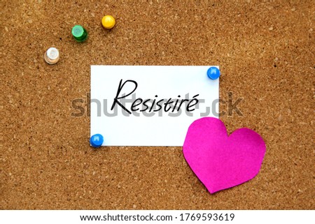 White note with "I will resist" message on cork board