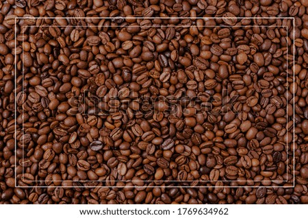 Background of grains of dark coffee with a frame for text. Design concept. Copy of the space.