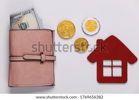 Family, home budget. The concept of buying or paying for housing Wallet with money, house figurine on a white background. Top view